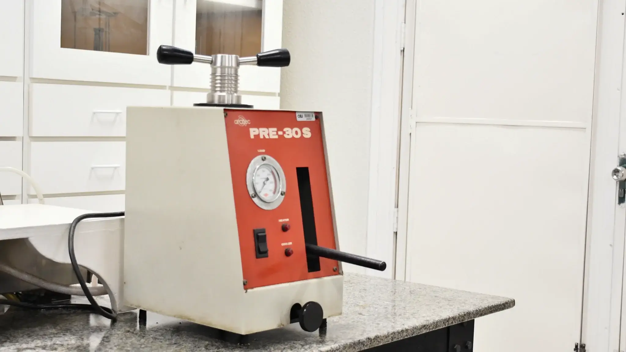Máquina de embutimento de amostras metálicas ou cer&acirc;micas utilizada no curso
